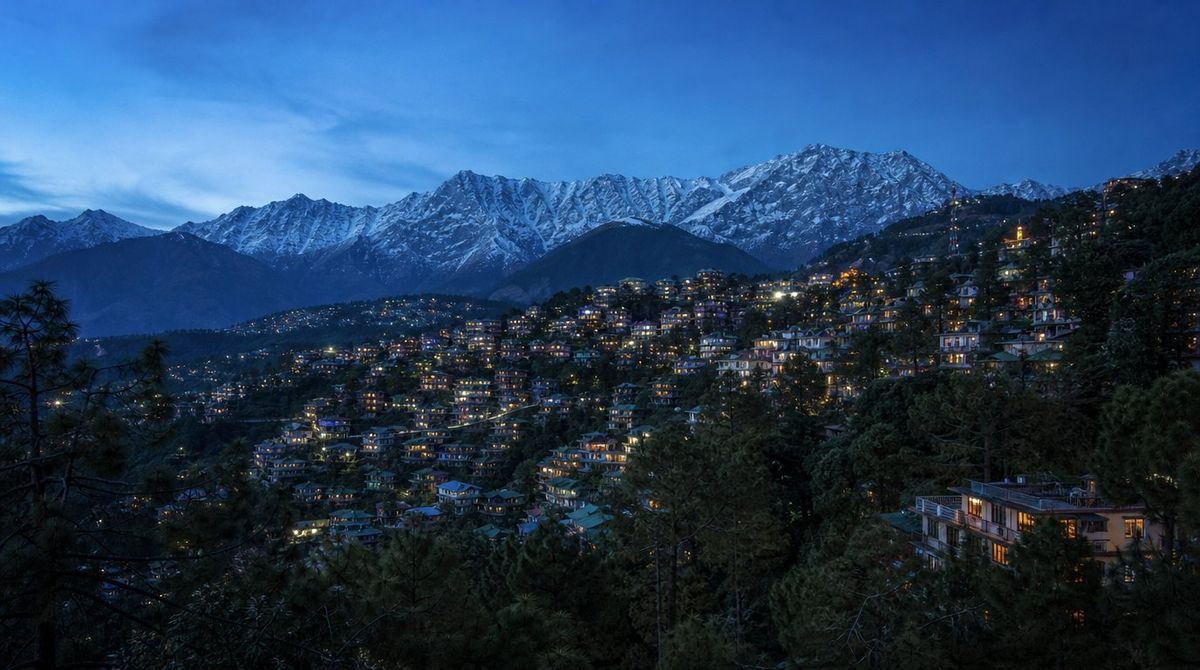 Dharamshala at dusk with the Dhauladhar range behind the town
